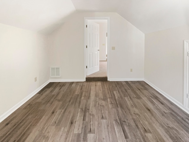 additional living space featuring lofted ceiling and dark hardwood / wood-style floors