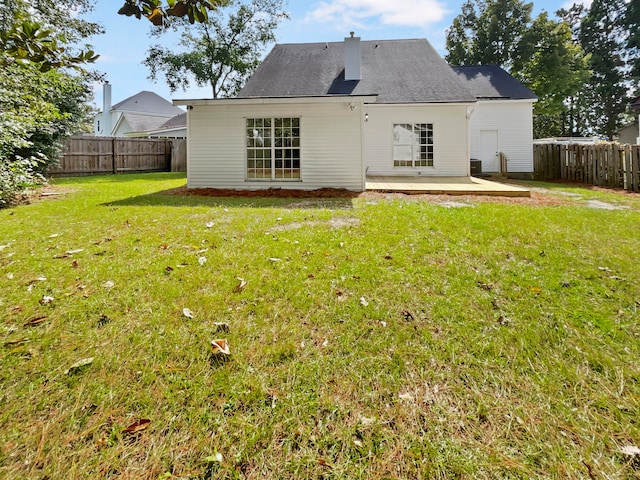 back of house with a lawn and a patio area