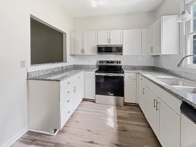 kitchen featuring white cabinets, light hardwood / wood-style floors, and appliances with stainless steel finishes