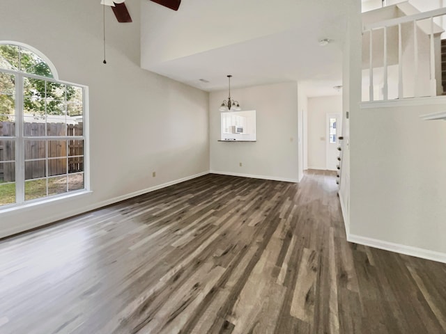 unfurnished living room with ceiling fan and dark wood-type flooring