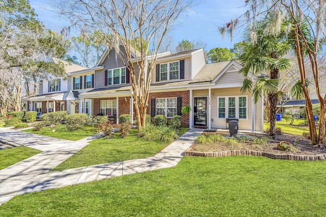 view of front of house with concrete driveway, brick siding, and a front lawn