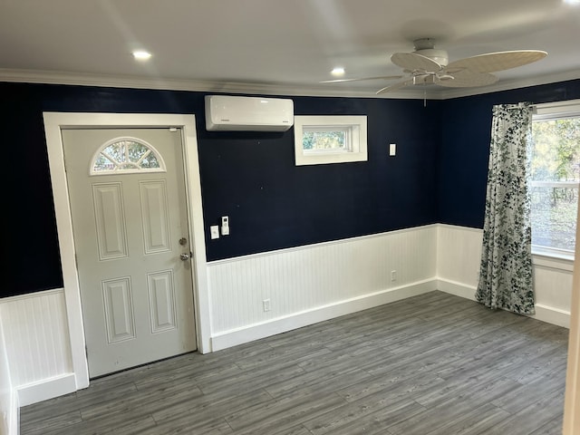 entryway featuring ceiling fan, wood-type flooring, crown molding, and a wall mounted AC