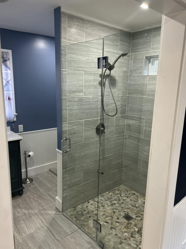 bathroom featuring a shower with door and vanity