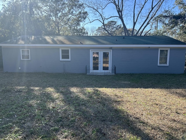 rear view of house with a lawn and french doors