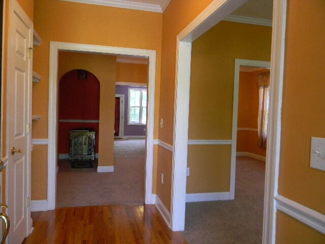 hall with crown molding and wood-type flooring