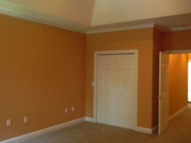 unfurnished bedroom featuring a closet, carpet, and ornamental molding