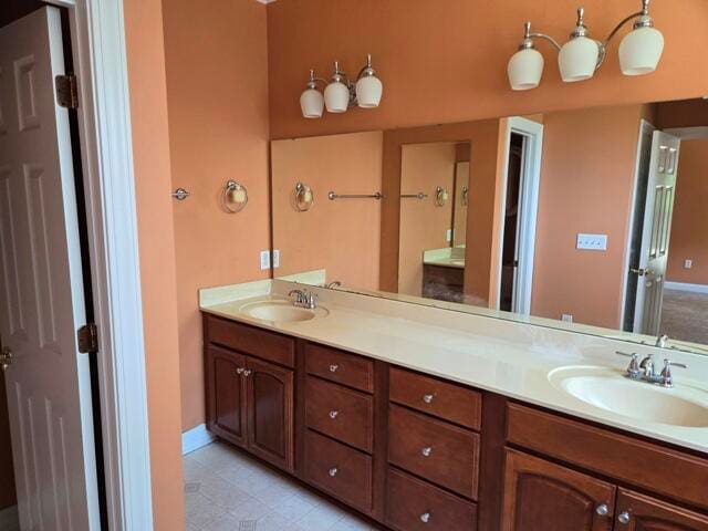 bathroom with vanity with extensive cabinet space, double sink, and tile floors