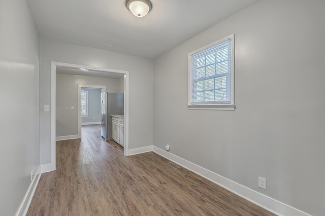 spare room with dark wood-style floors and baseboards