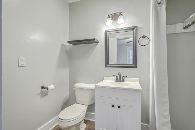 bathroom featuring baseboards, vanity, and toilet