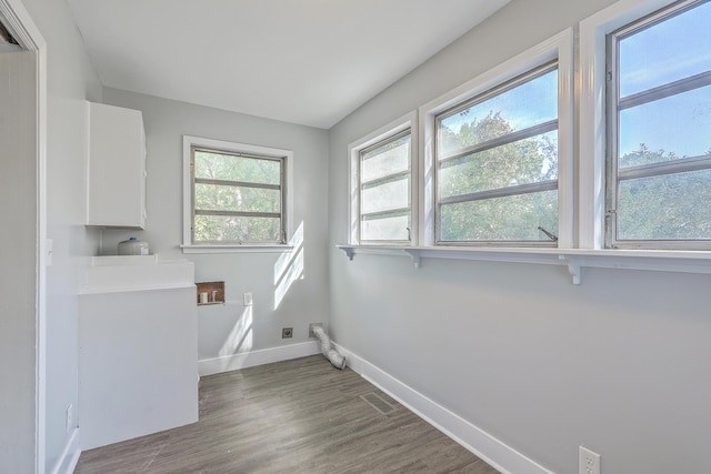 clothes washing area featuring laundry area, baseboards, and wood finished floors