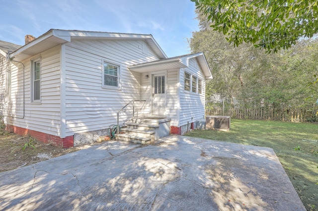 view of property exterior featuring a lawn and a patio