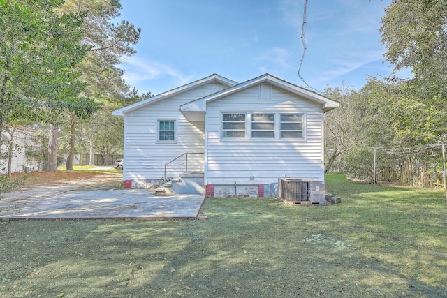 rear view of house with a yard and central AC unit