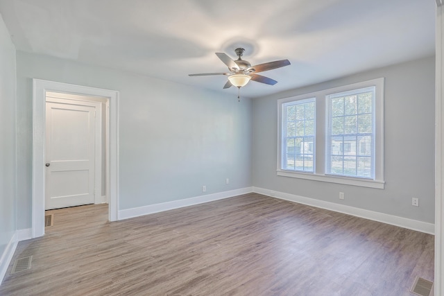 spare room featuring ceiling fan, wood finished floors, and baseboards