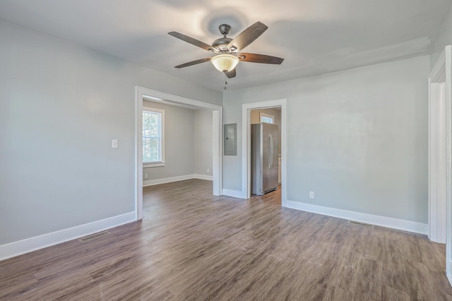 spare room featuring electric panel, visible vents, and dark wood-type flooring