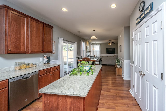 kitchen with stainless steel dishwasher, ceiling fan, light stone countertops, and a kitchen island