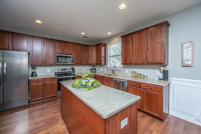 kitchen with light stone counters, dark wood-type flooring, appliances with stainless steel finishes, and a center island