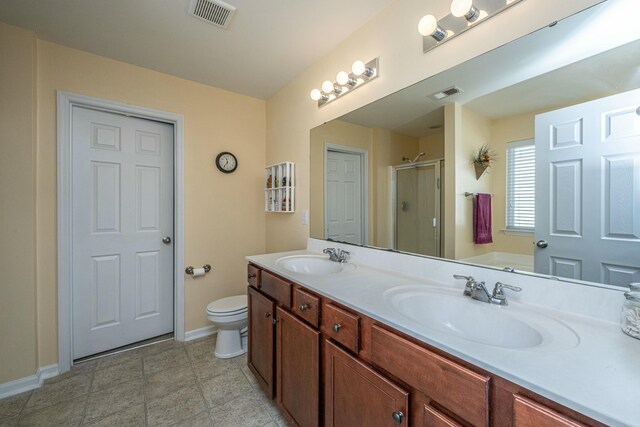 bathroom with toilet, a shower with shower door, and vanity