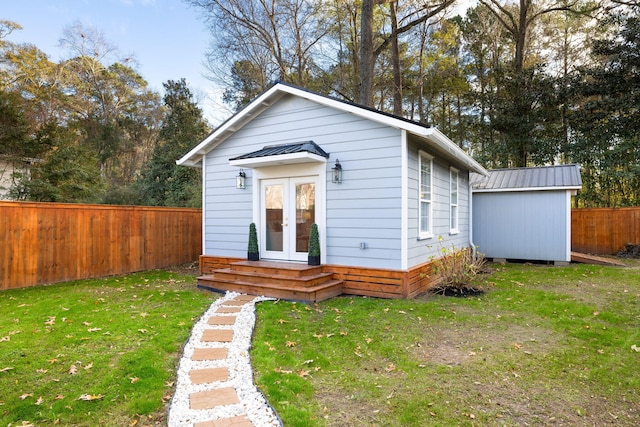 bungalow-style house with an outdoor structure and a front lawn