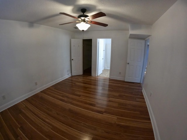 empty room featuring ceiling fan, dark hardwood / wood-style flooring, and a textured ceiling