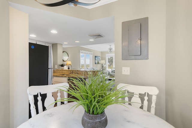 dining space featuring sink, electric panel, and ceiling fan