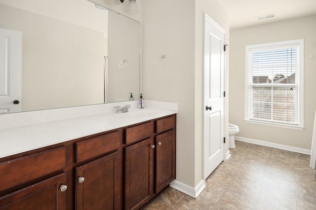 bathroom featuring toilet, visible vents, baseboards, and vanity