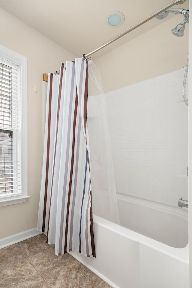 full bathroom featuring shower / bath combo and baseboards