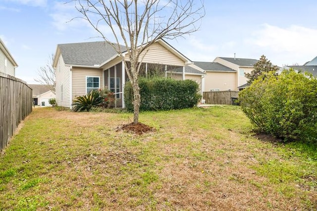 exterior space with a sunroom, fence, and a front lawn