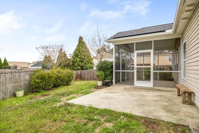 view of yard featuring a patio area, a fenced backyard, and a sunroom