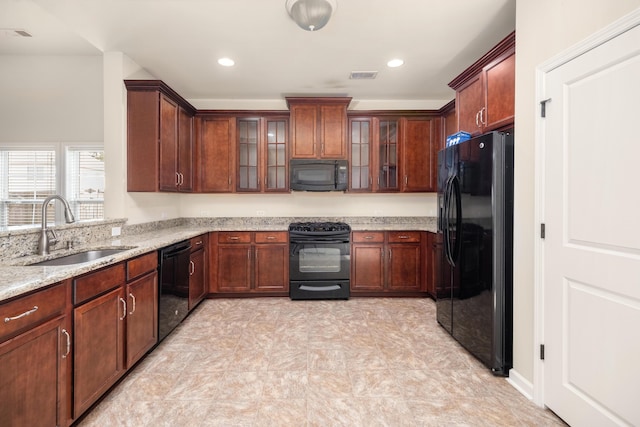 kitchen with light stone counters, recessed lighting, visible vents, a sink, and black appliances