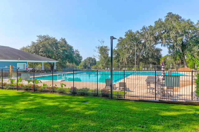 view of swimming pool featuring a patio area and a yard