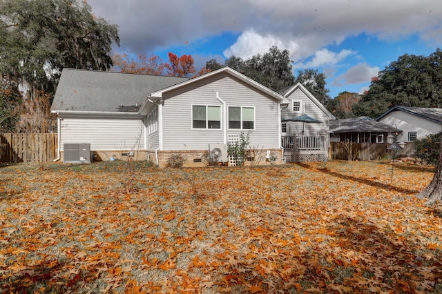 rear view of property with central AC unit and a wooden deck