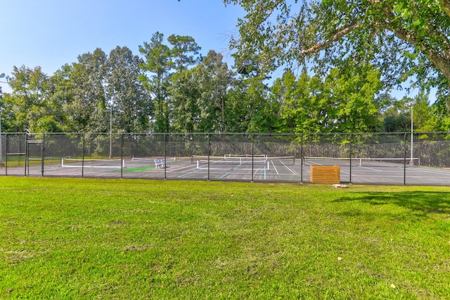 view of tennis court featuring a lawn