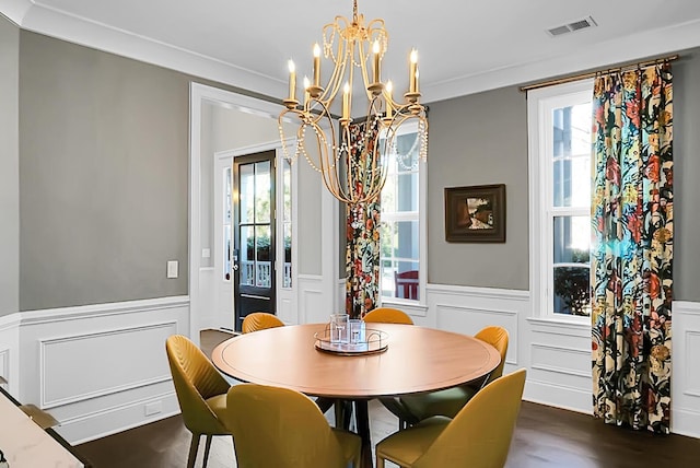 dining space featuring dark hardwood / wood-style flooring, an inviting chandelier, and crown molding