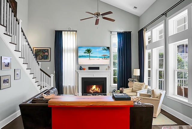 living room with ceiling fan, high vaulted ceiling, and wood-type flooring