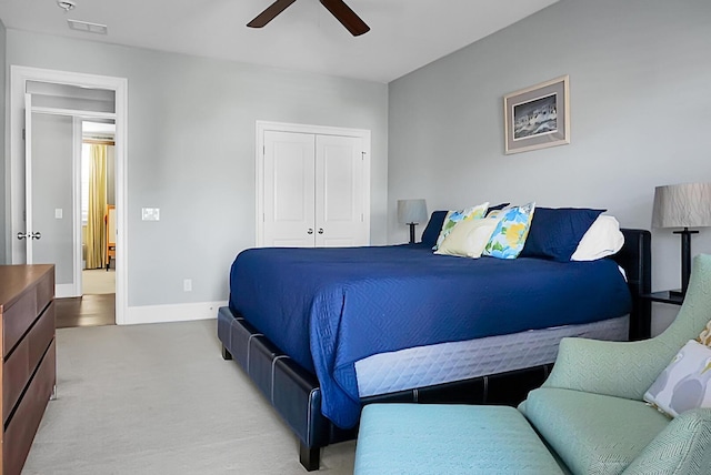 bedroom featuring ceiling fan, light carpet, and a closet