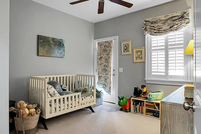 bedroom featuring ceiling fan and a crib