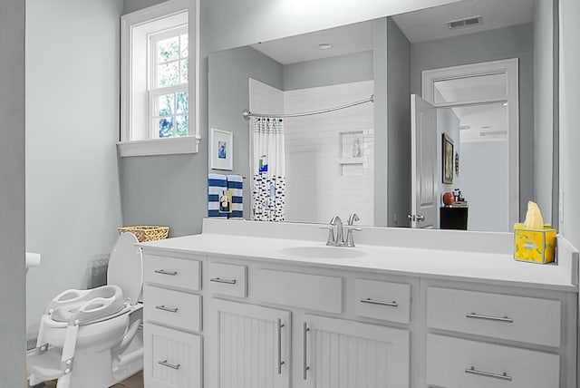 bathroom with vanity, curtained shower, and toilet