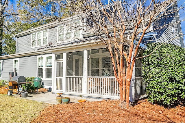 rear view of house featuring a sunroom