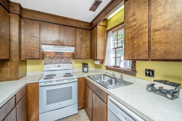 kitchen featuring white appliances, light tile patterned floors, and sink