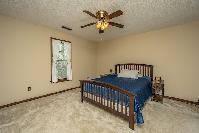 carpeted bedroom featuring a textured ceiling and ceiling fan