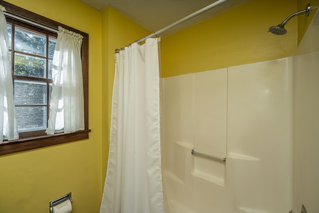 bathroom with a shower with curtain and a textured ceiling