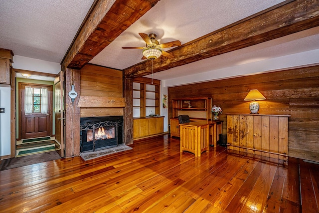 unfurnished living room featuring a textured ceiling, ceiling fan, and hardwood / wood-style flooring