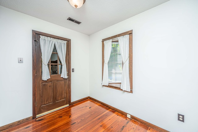 foyer entrance featuring a textured ceiling and hardwood / wood-style floors