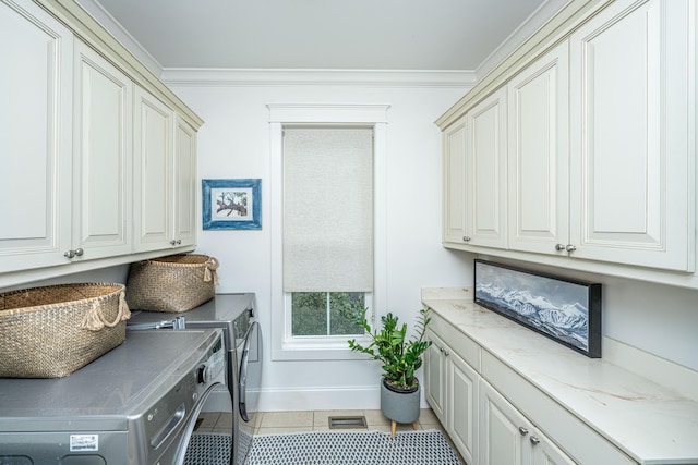 laundry area with crown molding, light tile patterned floors, cabinet space, and independent washer and dryer