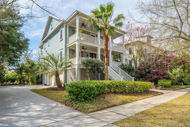 view of front of home with a balcony, a porch, ceiling fan, stairs, and concrete driveway