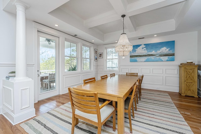 dining room featuring beam ceiling, a decorative wall, coffered ceiling, and ornate columns