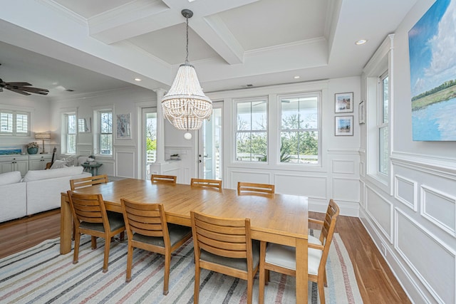 dining space featuring light wood finished floors, a decorative wall, beamed ceiling, and coffered ceiling