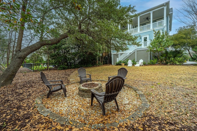 view of yard with ceiling fan, stairs, and an outdoor fire pit