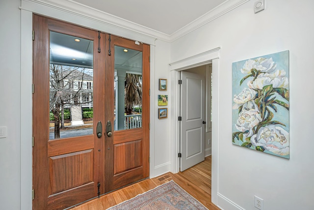 entryway featuring visible vents, light wood-style flooring, french doors, crown molding, and baseboards