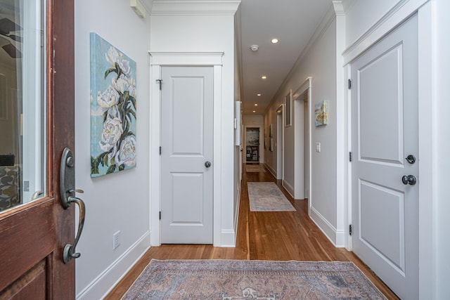 entrance foyer with crown molding, recessed lighting, wood finished floors, and baseboards